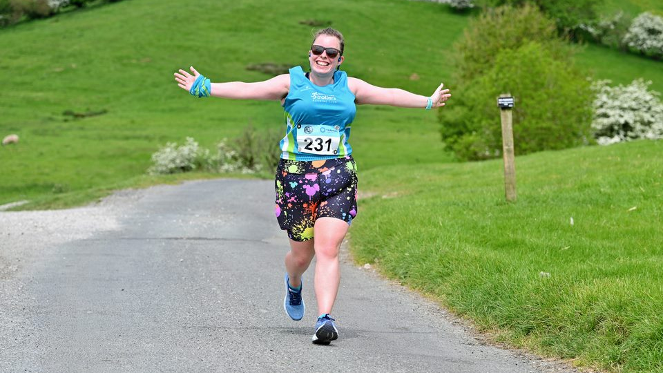 A smiling runner enjoying the Peak District course